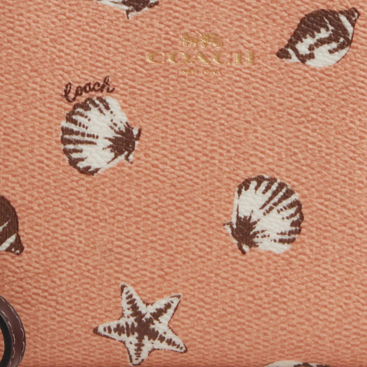 Closeup of Coach Corner Zip Wristlet with Shell Print - Coral/ Maple CBP23
