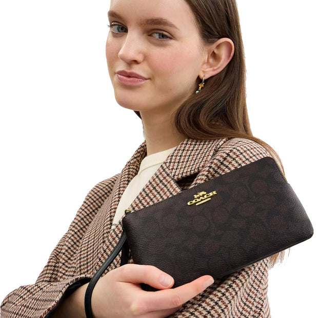 Model Holding Coach Large Corner Zip Wristlet In Signature Canvas - Walnut/ Black CZ277
