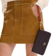 Model Carrying Coach Long Zip Around Wallet In Signature Canvas - Walnut/ True Red CW778