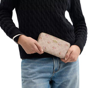 Model Wearing Coach Long Zip Around Wallet In Signature Canvas With Floral Print - Sand Multi CAR06