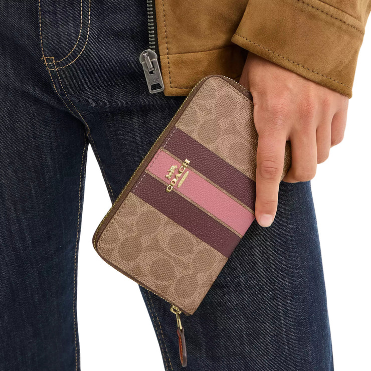 Model Carrying Coach Medium Id Zip Wallet In Signature Canvas With Varsity Stripe - Tan Multi CBO79
