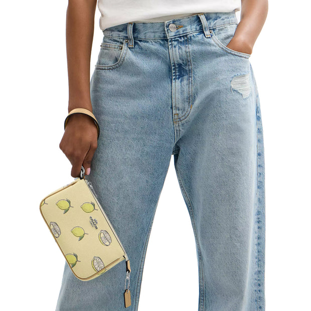 Model Holding Coach Nolita 19 Wristlet/ Top Handle/ Clutch Bag With Lemon Print - Garden Glade Multi CAL26