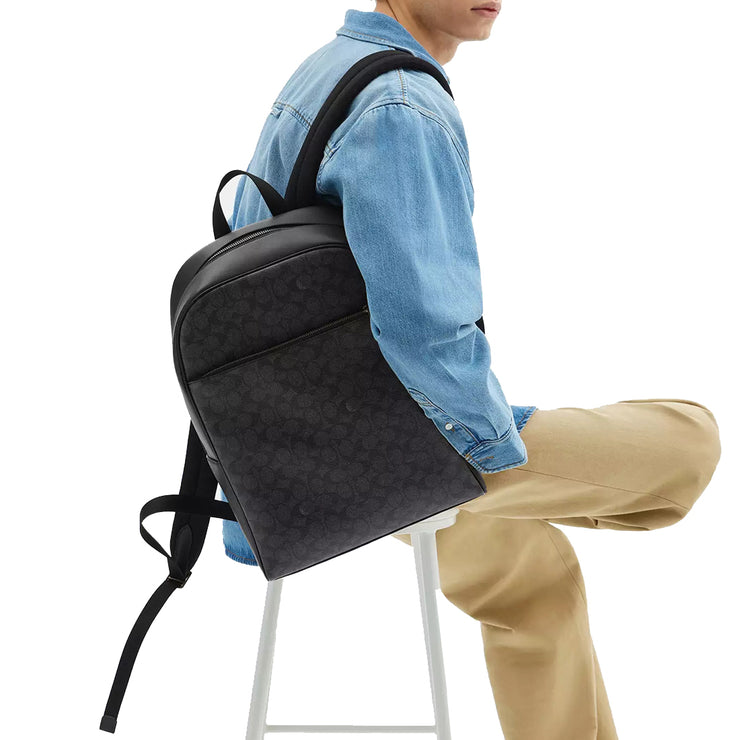 Male model carrying Coach Owen Backpack Bag In Signature Canvas - Charcoal/ Black CAJ90