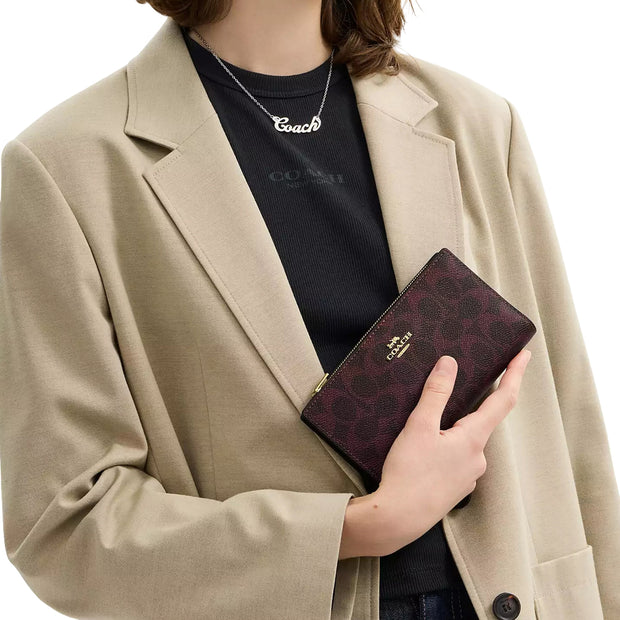 Model Wearing Coach Slim Zip Wallet In Signature Canvas - Black Currant CW661