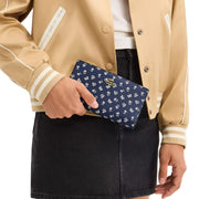 Model Carrying Coach Slim Zip Wallet With Floral Print - Deep Blue Multi CBO24