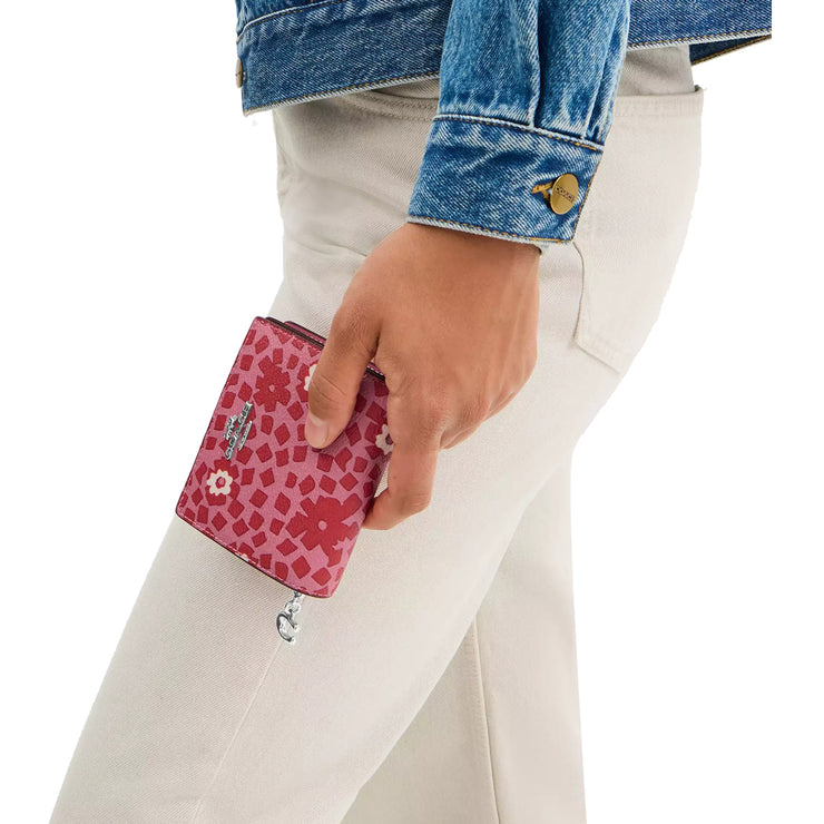 Model Holding Coach Snap Wallet With Floral Print - Pink Multi CBO75
