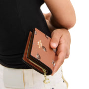 Model Holding Coach Snap Wallet With Shell Print - Coral/ Sunrise CBO73