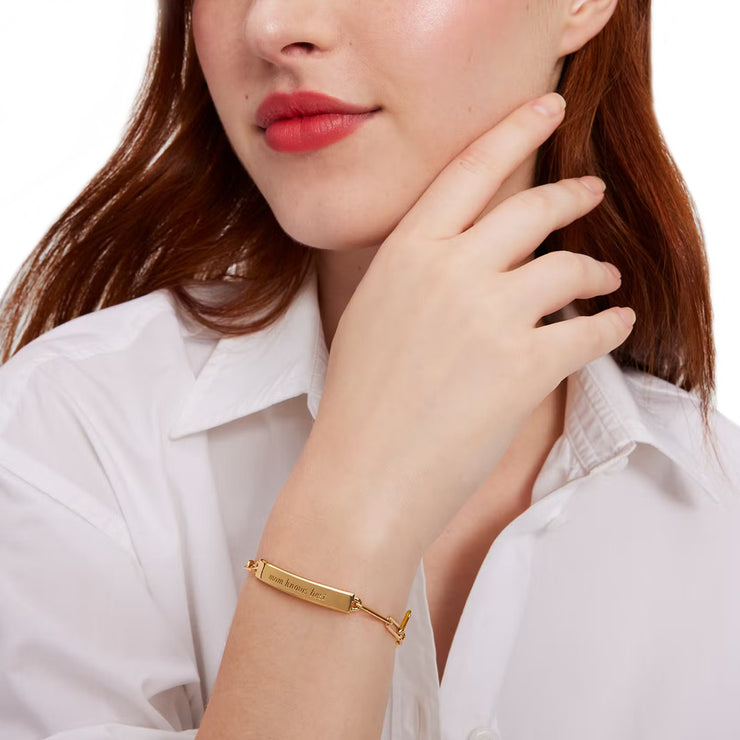 Female Model Wearing Kate Spade Mom Knows Best Idiom Id Bracelet in Gold KG408